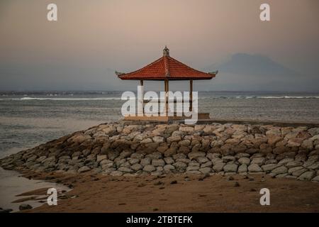 Morning landscape taken at the sandy beach, view over the sea to the volcano Mount Agung, panorama of the sunrise at the sandy beach of Sanur, Bali, Indonesia Stock Photo