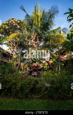 Park with tropical plants and traditional statues of the Hindu faith and for decoration, tropical island life as a tourist in Bali, Indonesia Stock Photo