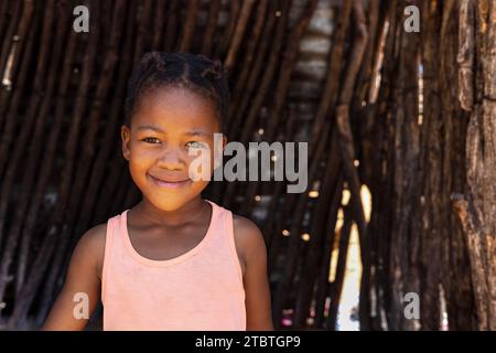 african girl standing in front of the outdoors kitchen in the yard, village in Botswana Stock Photo