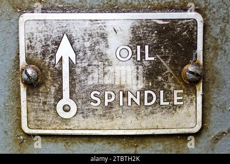 Close-up of Aged Industrial Oil Spindle Plaque on Machinery Stock Photo