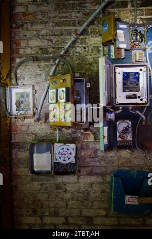 Vintage Industrial Decay: Weathered Electrical Panels on Distressed Brick Wall Stock Photo