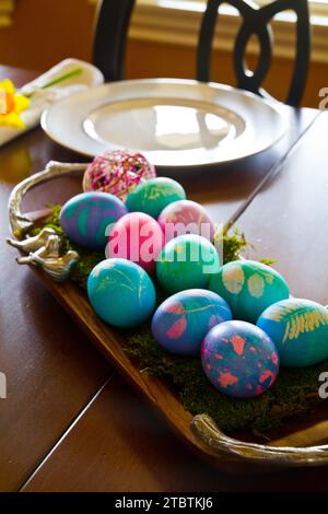 Colorful Handmade Easter Eggs on Rustic Tray in Home Setting Stock Photo