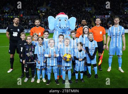 Young Coventry City fans pose with club mascot Sky Blue Sam, and team captains Lukas Jutkiewicz of Birmingham City (left) and Ben Sheaf of Coventry City (right) before the Sky Bet Championship match at the Coventry Building Society Arena, Coventry. Picture date: Friday December 8, 2023. Stock Photo