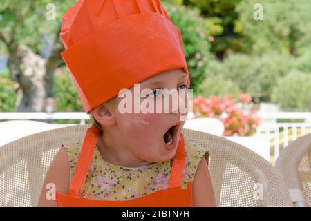 five-year-old girl yawns in class. Stock Photo