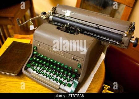 Vintage Typewriter with Green Keys on Wooden Desk in Warm Light Stock Photo