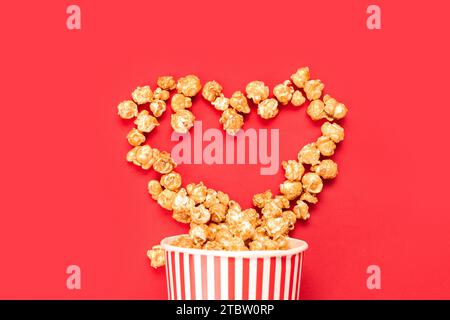 Heart made of popcorn on red background. Valentine's Day celebration Stock Photo