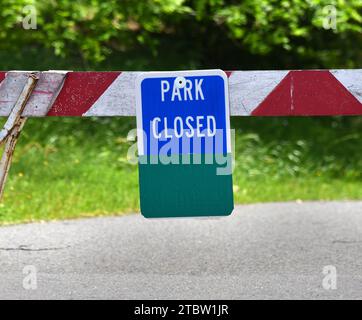 Close up of barrier that bars access to park area.  State park are closed due to spread of COVID 19 virus.  Barrier is red and white striped with a bl Stock Photo