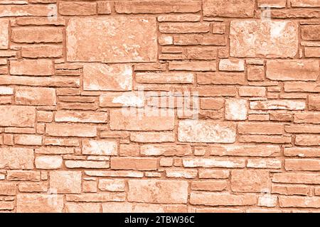 Color of the year 2024: Peach fuzz. Plain stone wall. Stock Photo