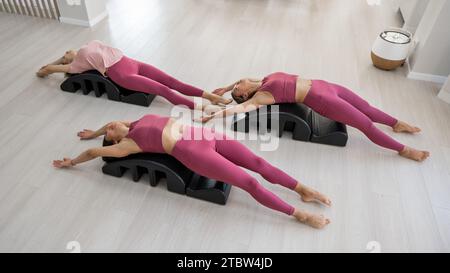 Balanced Body Pilates Arc. Three asian women exercising on pilates arc.  Stock Photo