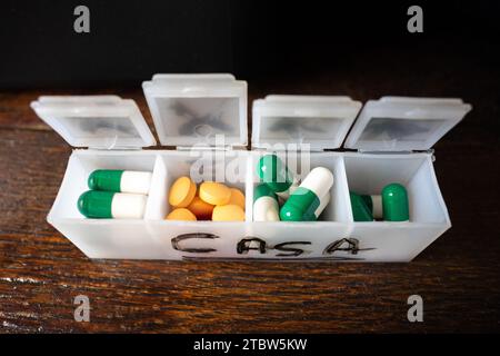 pill organizer box, with orange pills and other green ones Stock Photo