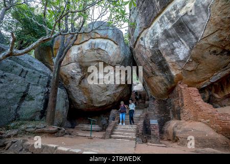 Visitors to Sigiriya Rock Fortress in Sri Lanka pass through Boulder Arch Number One. This formed part of the ancient pathway to the rocks summit. Stock Photo