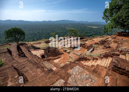 The spectacular view from the summit of Sigiriya Rock Fortress in Sri Lanka showing various ancient red brick walls and stairs. Stock Photo