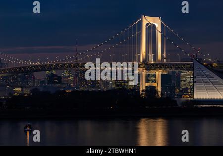 A picture of the Rainbow Bridge, illuminated in white, at night (Tokyo) Stock Photo