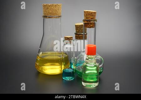 Assorted colourful solutions or essential oils in glass containers with stoppers over a grey background in a conceptual image Stock Photo