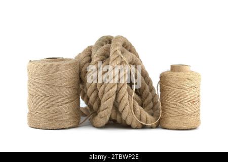 Jute rope and spools of burlap threads or jute twine in close-up over a white background. Eco friendly biodegradable material Stock Photo