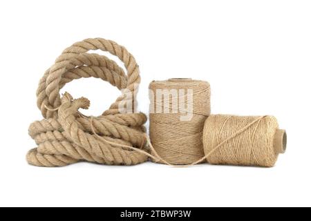 Twisted jute rope and spools of burlap threads or jute twine isolated on white background. Eco-friendly biodegradable material Stock Photo