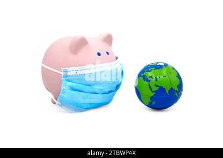 Pink piggy bank with protective medical face mask and earth globe isolated on white background. Banking during a pandemic concept Stock Photo