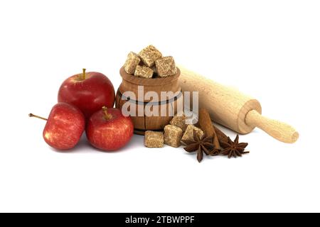 Cinnamon sticks, brown sugar cubes and anise stars placed in wooden scoop near red apples and rolling pin Stock Photo