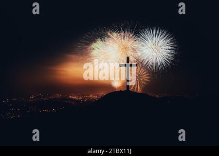 Christmas fireworks festival and fireworks to celebrate the holiday season and New Year, New Year's night cityscape and church cross silhouette Stock Photo