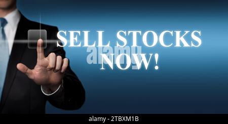 sell stocks now - businessman pressing virtual touchscreen button Stock Photo