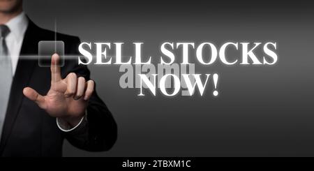 sell stocks now - businessman pressing virtual touchscreen button Stock Photo