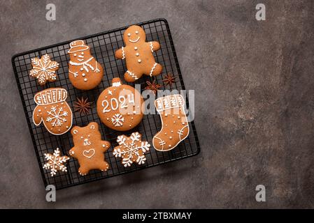 Set of Christmas gingerbread cookies on a cooling rack, brown rustic background. Top view, flat lay, copy space. Stock Photo