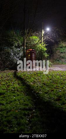 A telephone box re-purposed to house a defibrillator at night, Kent. Stock Photo