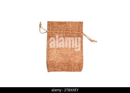 One empty peach fuzz colored cotton fabric bag (beige burlap pouch) isolated on white background. Copy space for text. Selective focus. Stock Photo