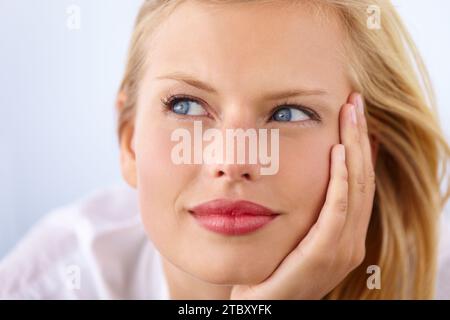 Woman thinking, student ideas and smile for learning, education and scholarship or college choice in studio. Face of a young person with vision for Stock Photo