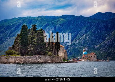 The monastery on the Island of Saint George stands out in the Bay of Kotor near Perast, Montenegro with Our Lady of the Rocks in the distance nearby. Stock Photo