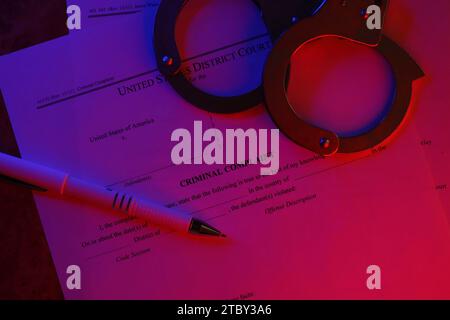 District Court Criminal complaint court papers with handcuffs and blue pen on table close up Stock Photo