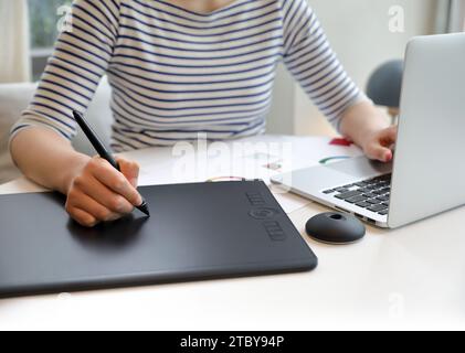 Woman who creates NFT works using tablet Stock Photo