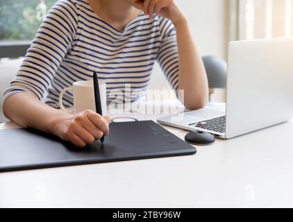 Woman who creates NFT works using tablet Stock Photo