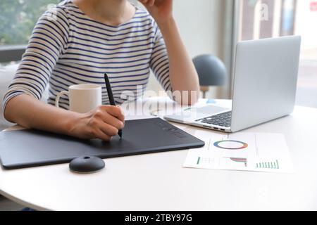 Woman who creates NFT works using tablet Stock Photo