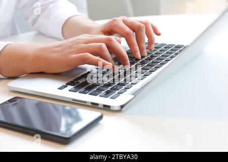 Two hands typing on laptop at desk Stock Photo