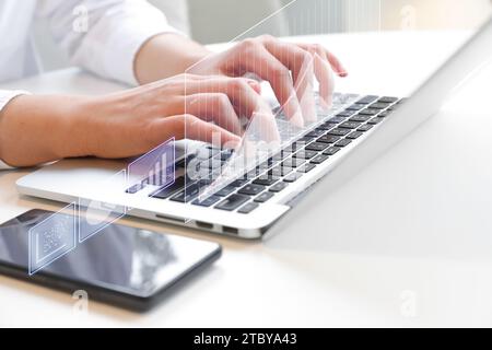 Two hands typing on laptop at desk (finance, investment related holographic projection) Stock Photo