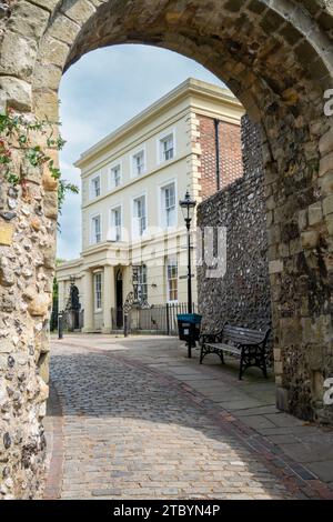 A brick path through the archway of Lewes Castle with the grade II listed Castlegate House in the background. Stock Photo