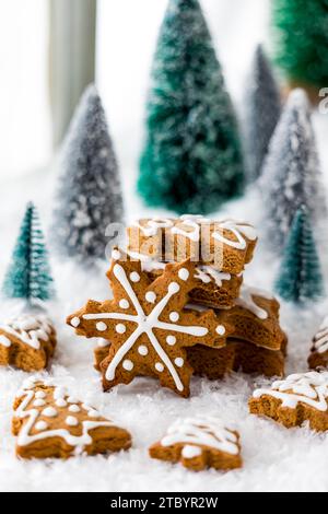 An arrangement of various gingerbread cookies surrounded by trees and snow. Stock Photo
