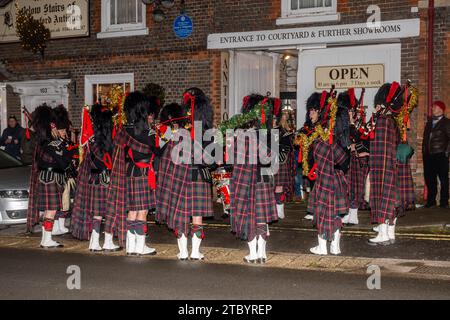 8th December 2023. The Hungerford Victorian Extravaganza, an annual Christmas event, took place in the West Berkshire town, England, UK. The evening features a parade, with Christmas street fair, festive music, food and drinks and steam engines. Pictured: Reading Scottish Pipe Band playing bagpipes and entertaining people. Stock Photo