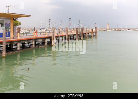 DESENZANO DEL GARDA, Italy - August 26, 2023: Pier on the lake Garda, with the marina and the lighthouse in the background Stock Photo