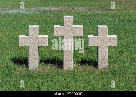 Three catholic stone crosses on young green grass at the German military cemetery in Rossoshki. Volgograd. Russia Stock Photo