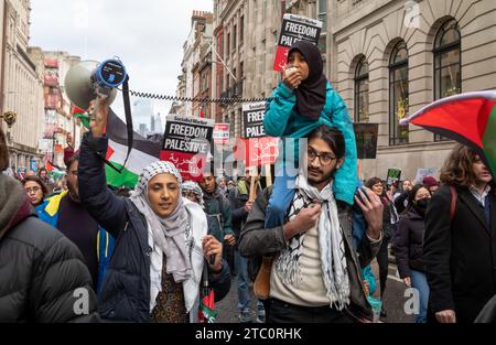 London, UK. 9 Dec 2023: A father carries his daughter who leads chants with her mother  at a pro-Palestinian demonstration calling for an end to Israeli attacks on Gaza. Credit: Andy Soloman/Alamy Live News Stock Photo