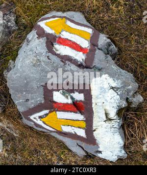 red and yellow tourist signs symbols with arrows is used in Czech republic and Slovakia for tourist navigation, marked on stone background Stock Photo