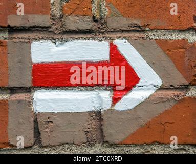 red and white hiking trail signs symbols on brick wall background Stock Photo