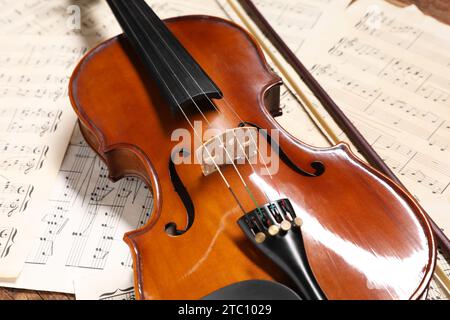 Violin, bow and music sheets on table, closeup Stock Photo
