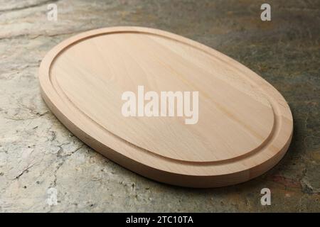 Wooden cutting board on textured table, closeup Stock Photo