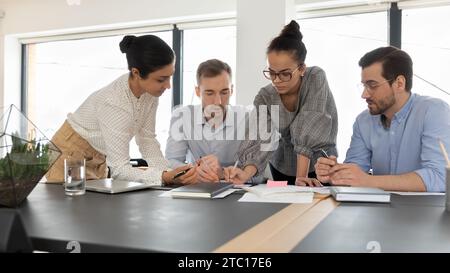 Diverse colleagues work on financial documents at meeting Stock Photo