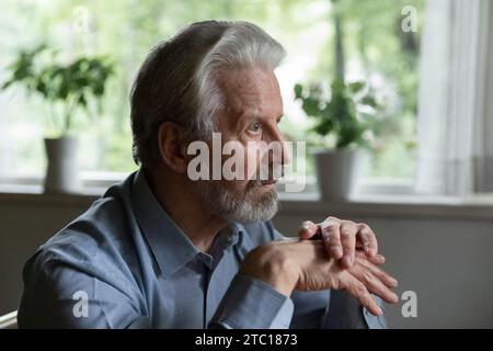 Unhealthy mature grey haired man retiree stare straight before himself Stock Photo