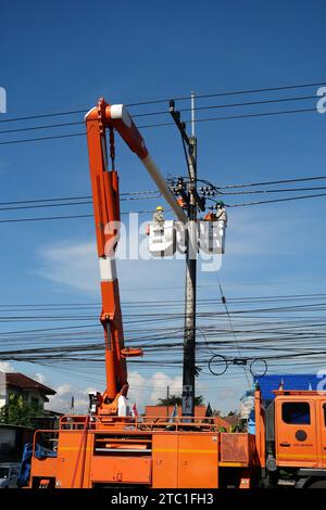 CHIANG MAI, THAILAND November 14, 2023 : Electricity worker repairs High voltage electrical wires. Stock Photo