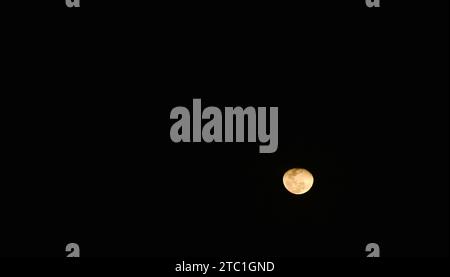 bright yellow full moon floating on sky in night Stock Photo
